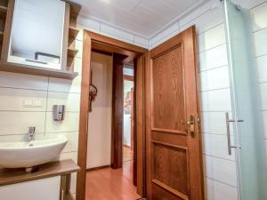 ein Badezimmer mit einem Waschbecken und einer Holztür in der Unterkunft Apartment Zander by Interhome in Sankt Kanzian am Klopeiner See