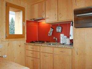 een keuken met houten kasten, een wastafel en een raam bij Studio Montagnards 13 by Interhome in Villars-sur-Ollon