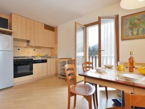 een keuken en eetkamer met een tafel en stoelen bij Apartment Al Parco-3 by Interhome in Canazei