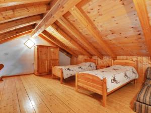 two beds in a room with wooden ceilings at Apartment Villa Placidia Apt 31 by Interhome in Campitello di Fassa