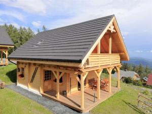 a large wooden cabin with a black roof at Chalet Buchfink by Interhome in Hochrindl