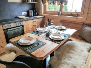 einen Holztisch mit Tellern und Weingläsern darauf in der Unterkunft Chalet Buchfink by Interhome in Hochrindl