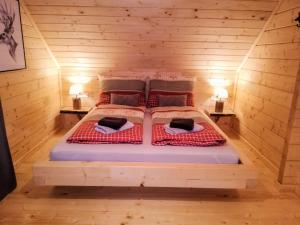 ein Schlafzimmer mit einem Bett in einem Holzzimmer in der Unterkunft Chalet Buchfink by Interhome in Hochrindl