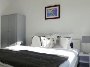 a bedroom with a bed with white sheets and pillows at Holiday Home Landhaus Inselsee by Interhome in Mühl Rosin