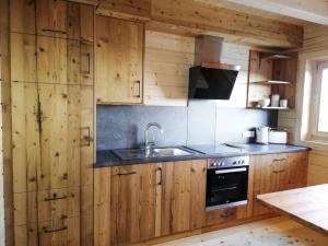 a kitchen with wooden cabinets and a sink at Chalet Hütte Gimpel by Interhome in Hochrindl