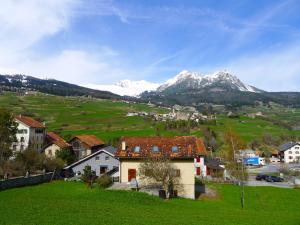 un village avec des montagnes enneigées en arrière-plan dans l'établissement Apartment Sur Baselgia by Interhome, à Cunter