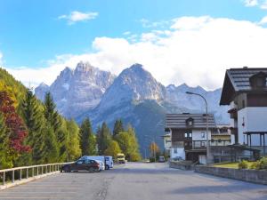 a street with cars parked in front of a mountain at Apartment Frassan Apartments-2 by Interhome in Madonna di Campiglio