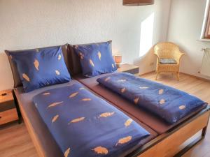 Una cama con edredón azul y almohadas. en Apartment Winterhalder by Interhome, en Eisenbach