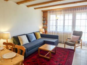 sala de estar con sofá azul y mesa en Apartment Aiguilles Dorées I-2 by Interhome, en Villars-sur-Ollon