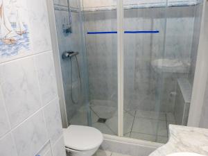 een badkamer met een douche, een toilet en een wastafel bij Apartment Le Capricorne by Interhome in Cabourg