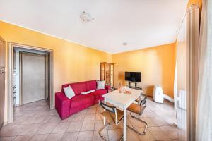 salon z czerwoną kanapą i stołem w obiekcie Annamaria 9 Apartment by Wonderful Italy w Sirmione