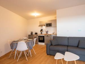 een woonkamer met een bank en een tafel en stoelen bij Apartment Les Cavaliers by Interhome in Cabourg
