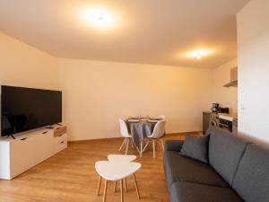 een woonkamer met een bank en een tafel met stoelen bij Apartment Les Cavaliers by Interhome in Cabourg
