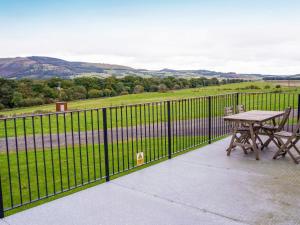 un patio con una mesa de picnic y una valla en Chalet Osprey Lodge by Interhome, en Kinross