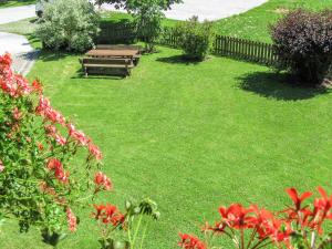 a garden with a picnic table and red flowers at Holiday Home Rossbrand by Interhome in Radstadt