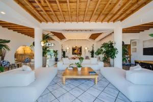 a living room with white furniture and a wooden ceiling at San Antonio Summerland in Mikonos