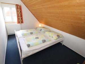 Lauterwasser的住宿－Holiday Home Holiday Hill 45 by Interhome，一张小床,位于一个拥有木制天花板的房间