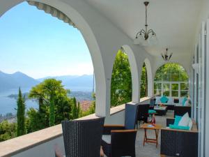 a room with chairs and tables with a view of mountains at Holiday Home Vernice Gialla-1 by Interhome in Minusio