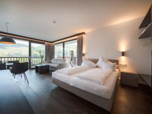 a bedroom with a large bed and a living room at Apartment Oberhofer-5 by Interhome in Telfes im Stubai