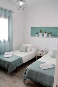 uma sala de estar com duas camas e uma janela em Casa Los Molinos em Villaverde