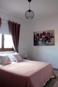um quarto com uma cama com uma pintura de flores na parede em Casa Los Molinos em Villaverde