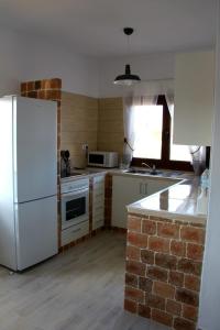 kuchnia z białą lodówką i ceglaną ścianą w obiekcie Casa Los Molinos w mieście Villaverde