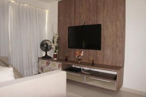 a living room with a flat screen tv on a wall at Pajuçara beach - 2 QUARTOS in Maceió