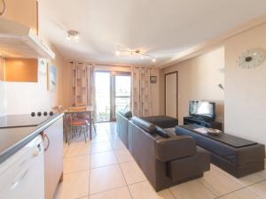 a living room with a couch and a table in a room at Apartment Firenze 108 with parking by Interhome in Bredene +8 photos