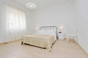 a white bedroom with a bed and a chair at Balestra in Rome