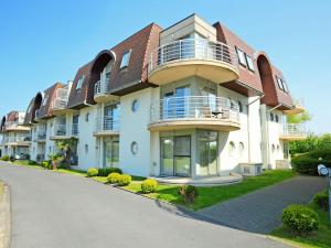 a large apartment building with balconies on a street at Studio Deauville II 010 with parking by Interhome in Bredene