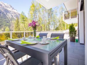 stół z wazonem kwiatów na patio w obiekcie Apartment Runhof Living by Interhome w Langenfeld +35 zdjęć