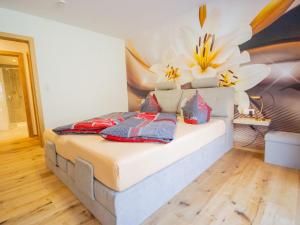 sypialnia z łóżkiem z kwiatem na ścianie w obiekcie Apartment Runhof Living by Interhome w Langenfeld