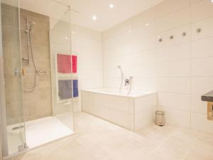 łazienka z prysznicem, wanną i umywalką w obiekcie Apartment Runhof Living by Interhome w Langenfeld