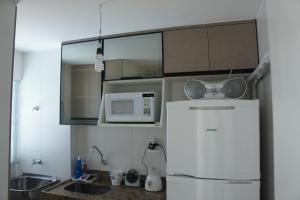 a kitchen with a white refrigerator and a microwave at Pajuçara beach - 2 QUARTOS in Maceió
