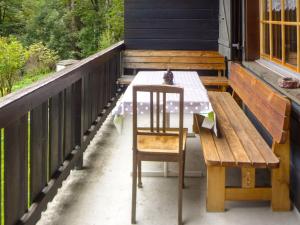 einen Tisch und eine Bank auf der Veranda eines Hauses in der Unterkunft Apartment Chalet l'Aube by Interhome in Vers L'Eglise