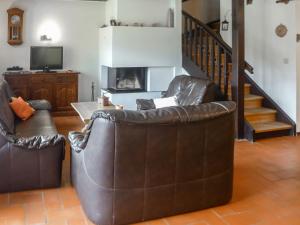a living room with two leather chairs and a staircase at Apartment Chalet l'Aube by Interhome in Vers L'Eglise