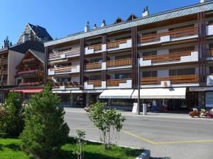 een groot gebouw met een straat ervoor bij Apartment Miremont A-B-C-4 by Interhome in Crans-Montana