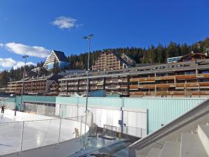 a tennis court in front of a large building at Apartment Miremont B7 by Interhome in Crans-Montana