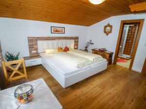 een slaapkamer met een groot wit bed en houten vloeren bij Apartment Weiherwirt by Interhome in Haslach