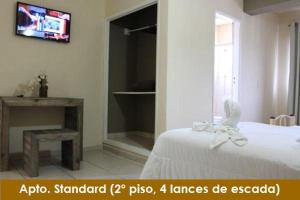 1 dormitorio con 1 cama y TV en la pared en Hotel Santiago en Lindóia