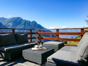 balcón con sofás y vistas a las montañas en Holiday Home Rustico Catcüc by Interhome en Malvaglia