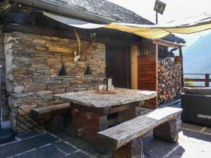 un bâtiment en pierre avec une table et un banc dans l'établissement Holiday Home Rustico Catcüc by Interhome, à Malvaglia