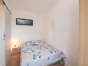 ein kleines weißes Schlafzimmer mit einem Bett in einem Zimmer in der Unterkunft Apartment Plein Sud by Interhome in Cabourg