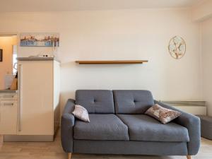 ein Wohnzimmer mit einem blauen Sofa in einem Zimmer in der Unterkunft Apartment Plein Sud by Interhome in Cabourg