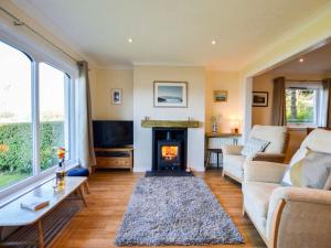 a living room with a couch and a fireplace at Holiday Home An Cala by Interhome in Oban