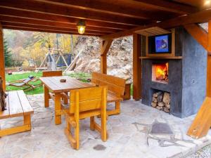 a patio with a wooden table and a fireplace at Chalet Mrklov by Interhome in Mrklov