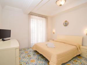 um quarto com uma cama e uma televisão de ecrã plano em Apartment Alba Home by Interhome em Sorrento
