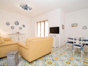 uma sala de estar com um sofá e uma televisão em Apartment Alba Home by Interhome em Sorrento
