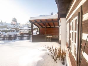 a wooden pergola on a house in the snow at Holiday Home Lánov by Interhome in Horní Lánov