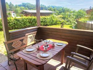 a wooden table and chairs on a porch with a table and chairs at Holiday Home Lánov by Interhome in Horní Lánov